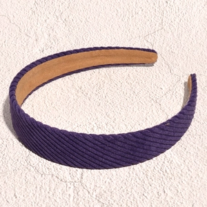 Detail view of purple corduroy headband texture with soft brown non-slip inner lining