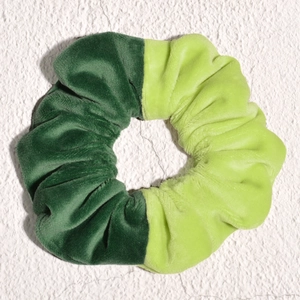 Detailed view of forest green and neon green velvet fabric contrast on hair scrunchie