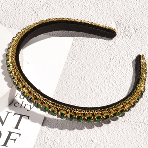 Detailed view of luxury velvet headband with green crystals and gold bead trim