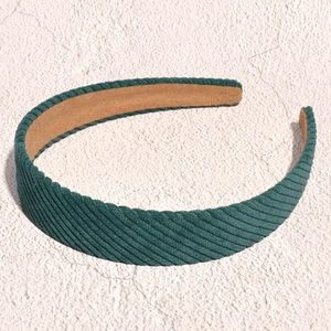 Detailed texture of dark green corduroy wide headband showing ribbed fabric and inner lining