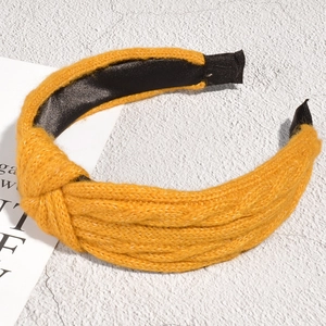 Detail of mustard yellow chunky knit headband with twist knot and black fabric lining