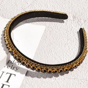 Detailed close-up of vintage black velvet headband with triple rows of golden rhinestones