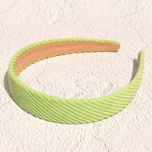 Detail of light green corduroy headband showing soft ribbed texture and non-slip lining