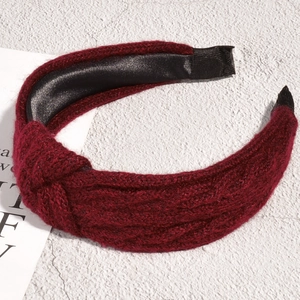 Detail of burgundy knitted knot headband with wool texture and black satin lining