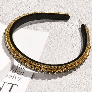 Detailed macro view of luxurious black velvet headband with sparkling rhinestones in gold setting