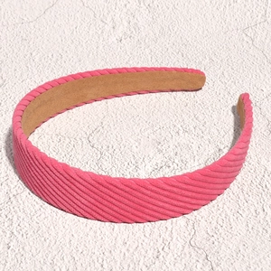 Detail of pink corduroy headband with soft ribbed texture and anti-slip suede lining