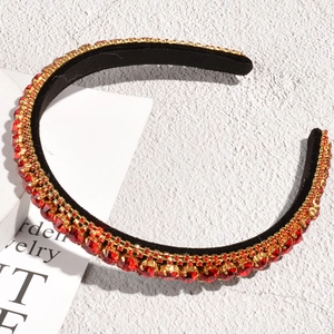 Detail of red and gold rhinestones on velvet headband with vintage luxury design