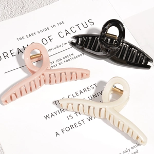 Three minimalist hair claw clips in pink black and cream white with metal springs