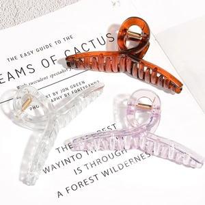 Three-piece set of large acrylic hair claws in amber, clear, and lilac on a card