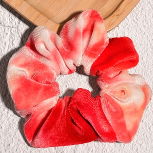 Detalle del coletero de terciopelo degradado rojo y rosa sobre bandeja de madera
