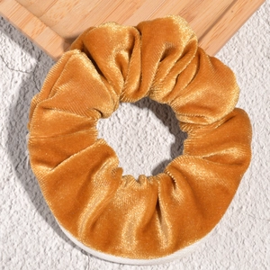 Detailed macro shot of ginger velvet hair scrunchie with hidden zipper pocket feature