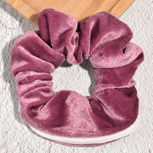 Detail showing deep purple velvet scrunchie with hidden white zipper storage pocket