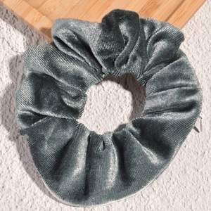 Close-up of velvet scrunchie featuring a hidden zipper pocket in silver grey