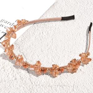 Detailed macro view of baroque headband with champagne crystals on a marble stone surface
