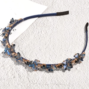 Detail of baroque crystal headband featuring blue faceted beads on a satin wrapped band