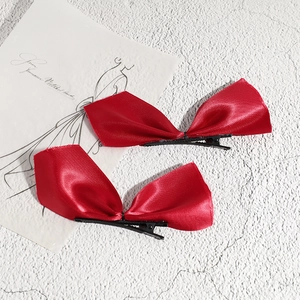 Paire de nœuds à cheveux en satin rouge élégant avec texture soyeuse et pince crocodile