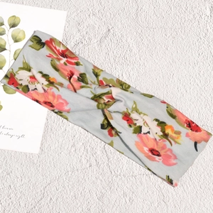Λεπτομέρεια από floral κορδέλα με σταυρωτό κόμπο και ροζ λουλούδια σε γαλάζιο ύφασμα