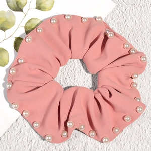 Pink coral pleated scrunchie with white pearl accents and soft textured fabric for women