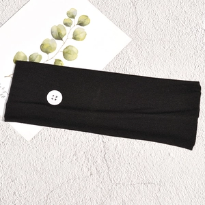 Detail of black sports headband with white buttons for masks on rock background