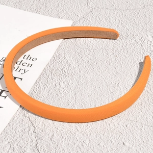 Detail of vibrant orange padded headband showing soft knit fabric and velvet lining