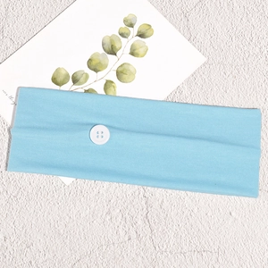 Detail of light blue knitted sports headband with a white button for mask relief