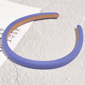 Detail of purple fabric headband with non-slip brown lining on a textured surface