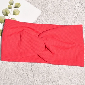Dettaglio della fascia per capelli in maglia a coste rosso corallo con nodo centrale