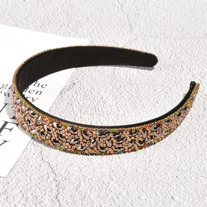 Close-up of champagne gold leaf headband with colorful rhinestones and beads
