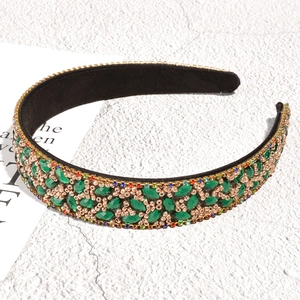 Detailed close-up of Baroque velvet headband with green rhinestones and golden beads