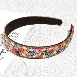 Detailed close-up of a Baroque headband with colorful rhinestones on a gold alloy base