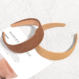 Fashionable wide braided raffia headbands in brown and beige with a vintage woven texture