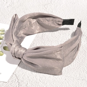 Detailed macro of the silver fabric knot and pleated texture on the wide headband