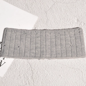 Détail du bandeau tricoté gris avec texture déchirée tendance et laine douce côtelée