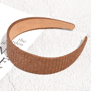 Close-up of brown woven raffia headband showing intricate natural fiber texture