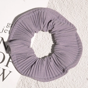 Detail view of purple pleated chiffon scrunchie with soft lilac fabric texture