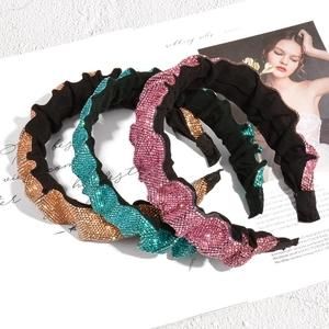 Macro detail of pleated headbands with sparkling rhinestones in champagne and green