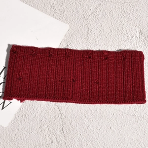 Détail du bandeau tricoté bordeaux avec textures pompons et tissu en coton côtelé doux