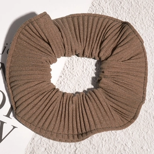 Detail of dark brown pleated fabric scrunchie with fine vertical textured ridges
