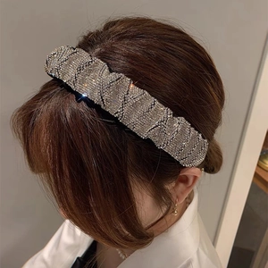 Sparkling rhinestone padded headband for women featuring a retro wavy crystal design