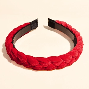 Detail eines roten geflochtenen Samt-Stirnbands mit Webe-Textur und rutschfesten Zähnen innen