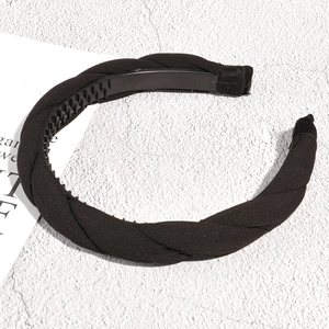 Detail of black braided headband with non-slip inner teeth and soft fabric texture