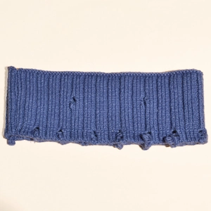 Gros plan du bandeau en coton bleu montrant la texture côtelée et les détails troués