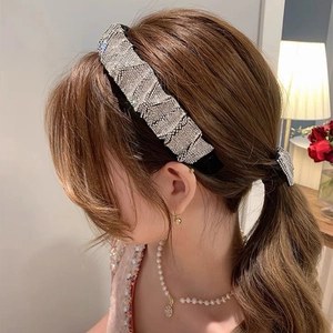 Detail shot of luxury pleated rhinestone headband and matching hair tie on a woman