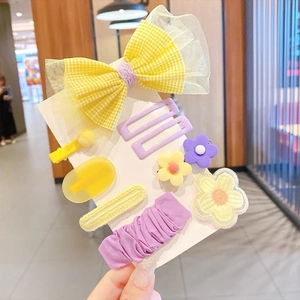 Set di fermagli per capelli per bambine con fiocco giallo e fiori viola su carta