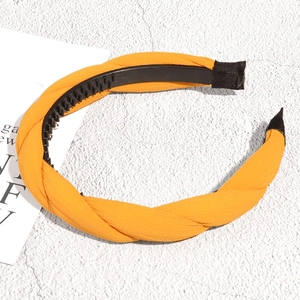 Detail of orange braided headband with anti-slip inner teeth and textured fabric