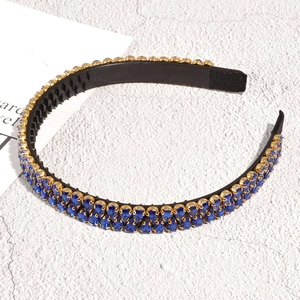 Vue détaillée du serre-tête en strass bleus avec griffes dorées et dents antidérapantes