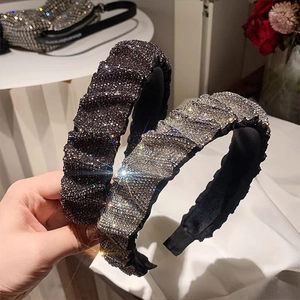 Close-up of wide ruched padded headband featuring sparkling full rhinestone embellishments