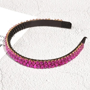 Vue détaillée des strass rose fuchsia sur le serre-tête noir avec dents antidérapantes