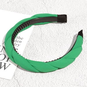 Detail of emerald green braided headband with inner non-slip teeth and fabric texture