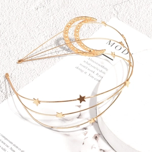 Golden multi-layer wavy metal headband with stars and pearl moon on marble background